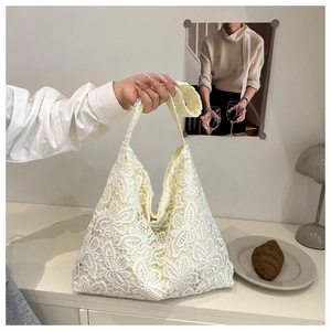 Détail de la broderie complexe en dentelle florale sur ce sac fourre-tout crème d'été
