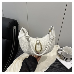 Détail du sac demi-lune blanc tressé avec boucle dorée en U et bandoulière à nœud décoratif