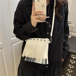 Sac bandoulière blanc chic avec franges et clous argentés porté par un modèle