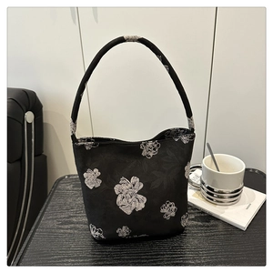 Vue détaillée du sac seau noir avec imprimés floraux élégants et poignée en tissu