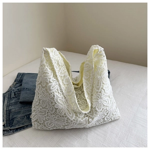 Gros plan détaillé du sac cabas en dentelle blanche avec motifs floraux en relief