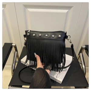 Détail de la bandoulière en similicuir noir avec rivets argentés et accents de franges