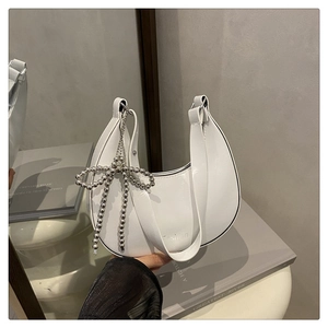 Détail du sac hobo blanc avec charm nœud en perles argentées et fermeture éclair