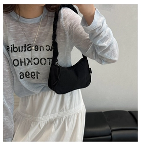 Détail du sac à bandoulière noir avec sangle froncée et texture en nylon de haute qualité