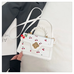 Macro shot of white cherry print handbag with golden flower lock and rope handle