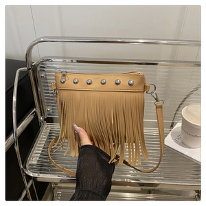 Dettaglio della borsa kaki con frange, rivetti argentati e tracolla rimovibile