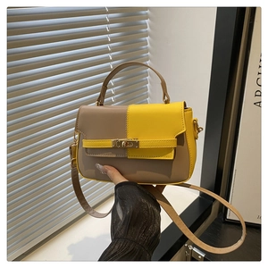 Detail of khaki and yellow patchwork Kelly style bag with golden metal turn lock closure