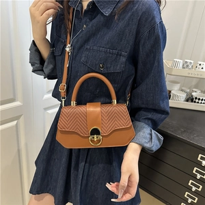 Brown woven and leather tote bag featuring a gold twist-lock and crossbody strap