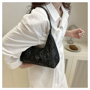 Detail of black snake pattern texture on minimalist hobo bag worn under the arm