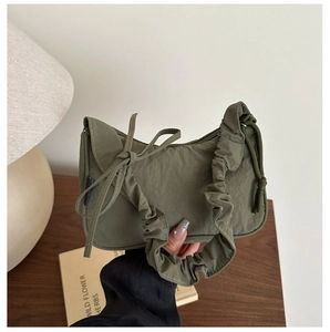 Détail du sac d'épaule en nylon vert armée avec nœud et bandoulière nuage plissée