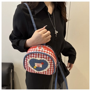 Detail of red and white checkered mini bag with blue denim heart and lace trim