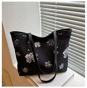 Détail du sac cabas floral noir avec rivets dorés et bandoulières en cuir synthétique