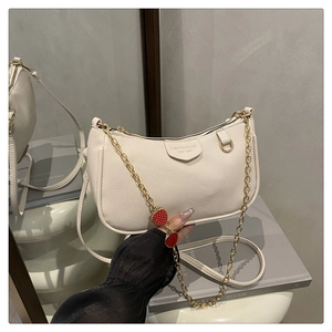 Detailansicht von Leder mit Litschi-Muster und Goldkette mit Erdbeer-Anhänger