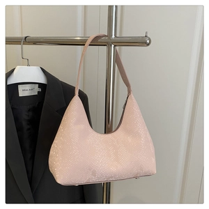 Detail of light pink faux snakeskin shoulder bag with textured surface and metal zipper