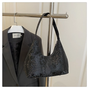 Macro detail of black snakeskin patterned hobo bag with textured scales and silver zipper