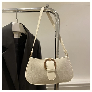 Detail der cremefarbenen Achseltasche mit großer vintage goldener Webschnalle im Fokus