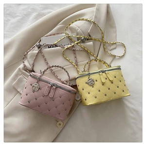 Detailed quilted crossbody bag with stud accents and a metal camellia flower pendant