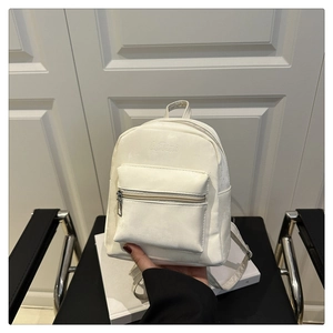 Close-up of minimalist white mini backpack showing leather texture and zipper details