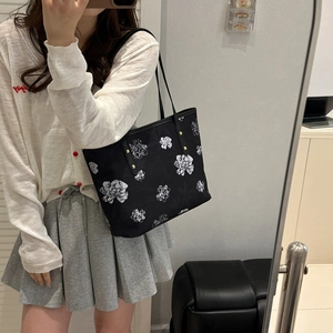 Grand sac cabas noir élégant avec motif floral blanc et rivets métalliques dorés