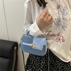 Minimalist color-block blue leather handbag with gold twist lock for crossbody or shoulder use