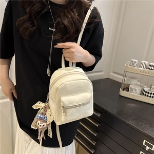 Minimalist cream white mini backpack for women featuring a cute plush bear charm