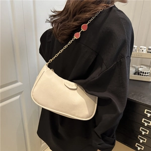 Schicke beige Unterarmtasche aus Leder mit dekorativer roter Erdbeer-Goldkettenschulter