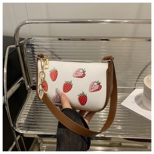 Détail du sac à bandoulière blanc imprimé fraises avec lanière cuir et chaîne dorée