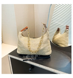 Dettaglio della borsa hobo intrecciata con catena dorata e inserti in pelle marrone