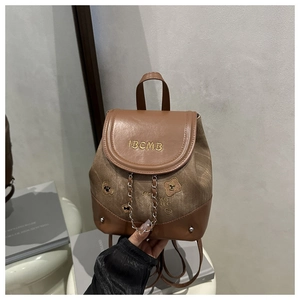 Detail of vintage canvas and brown leather backpack with bear embroidery and chain