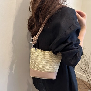Woven straw shoulder bag with pink leather trim and decorative knot detail