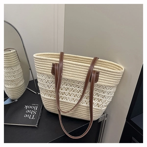 Detail of hand-woven straw tote bag with brown leather straps and beige mesh texture