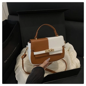 Detail view of contrast color handbag with gold twist lock and elegant gift box