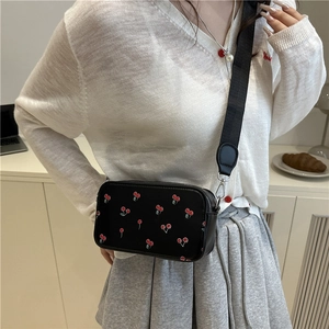 Minimalist black crossbody bag with red cherry print and wide nylon strap for women