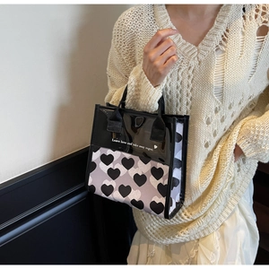 Dettaglio di una borsa a mano bianca e nera con stampa a cuore e cuciture eleganti