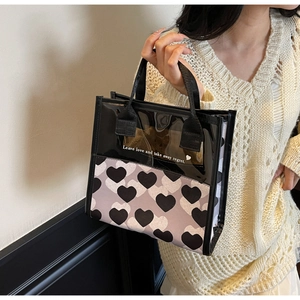 Dettaglio della borsa tote in tela con motivo a cuori e testo Leave love and take away
