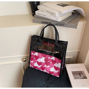 Dettaglio borsa trasparente in PVC con stampa a cuori e testo su velluto nero elegante
