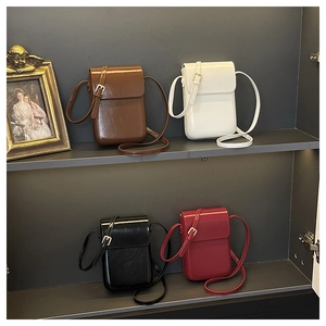 Vertical flap crossbody bags in brown, white, black and red shown on display shelves