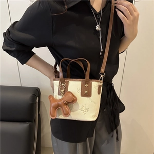 Bolso cubo beige elegante con relieve de mariposas y dije de perro para verano 2025