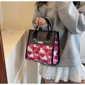 Dettaglio della borsa tote in tela con cuori rossi e inserto in PVC trasparente