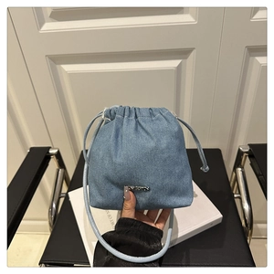 Dettaglio borsa a secchiello in denim azzurro con chiusura a coulisse e logo in metallo