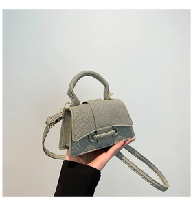 Detail of light grey textured mini bag with signature curved base and silver hardware