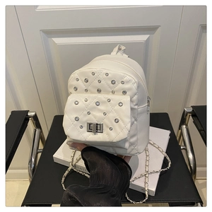 Gros plan du mini sac à dos matelassé blanc avec strass et fermoir rotatif en métal argenté