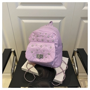 Détail du mini sac à dos violet matelassé avec clous argentés et fermoir rotatif en métal