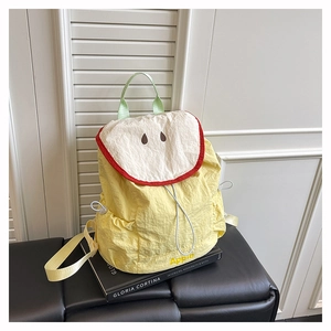 Vue détaillée du sac à dos en nylon à motif pomme sur un banc en cuir noir
