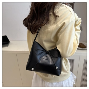 Detail of black bow shoulder bag featuring metallic beads and logo on smooth leather finish
