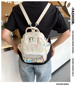 Detail eines beigen Canvas-Rucksacks mit transparenter Tasche und Plüschstern-Akzenten