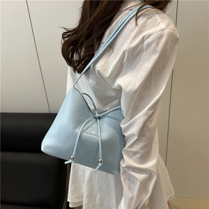 Minimalist light blue faux leather shoulder bag with drawstring and silver metal charms