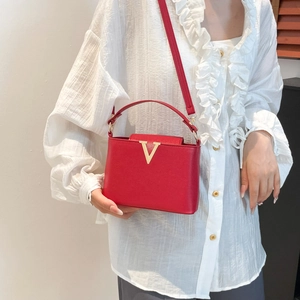 Sac seau rouge chic avec logo V doré, doté d'une poignée et d'une bandoulière réglable