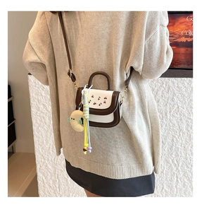 Détail du mini sac bandoulière crème avec broderie cerise et breloque lune en peluche