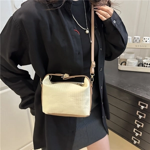 Chic cream square handbag with brown trim and vertical texture in a lifestyle setting